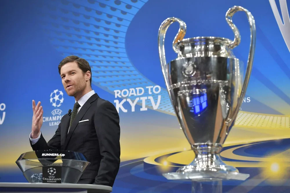 Xabi Alonso next to the Champions League torphy he claimed with Liverpool and Real Madrid