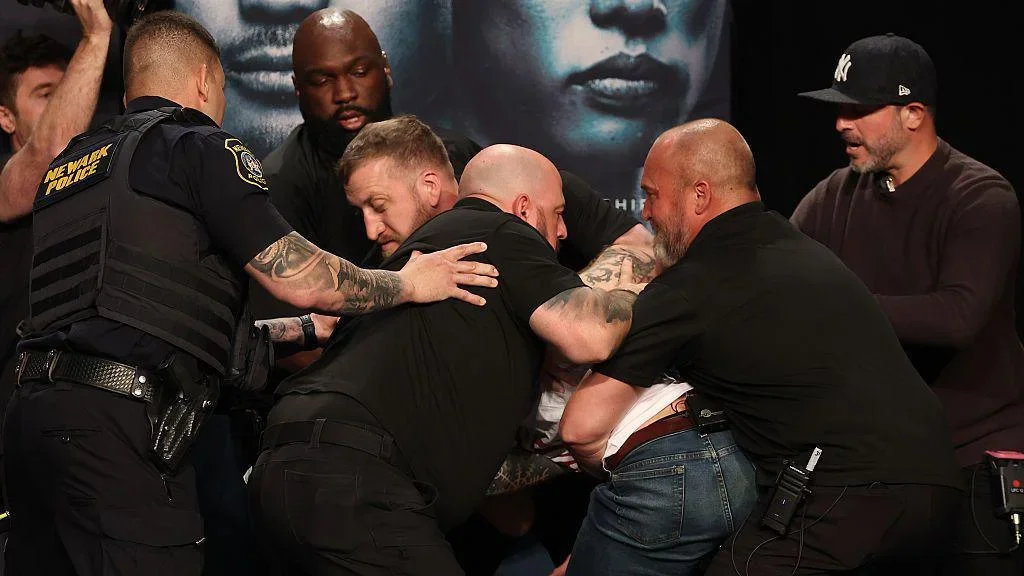 Security and armed police step in to separate Sean Strickland and Khamzat Chimaev at the UFC 328 news conference
