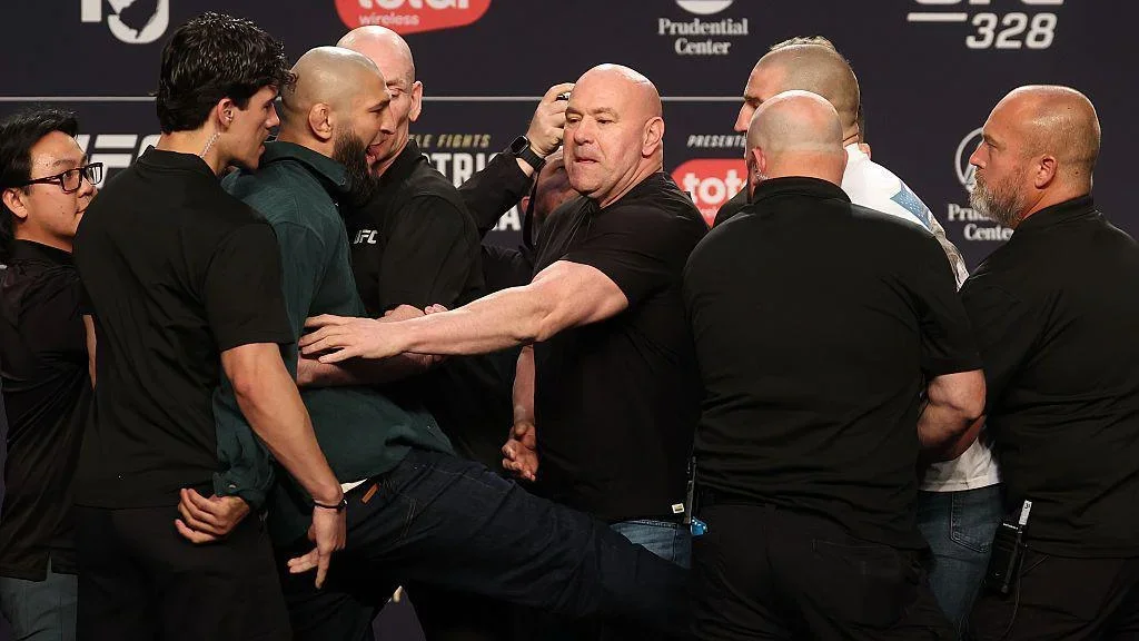 Khamzat Chimaev kicks Sean Strickland at the UFC 328 news conference